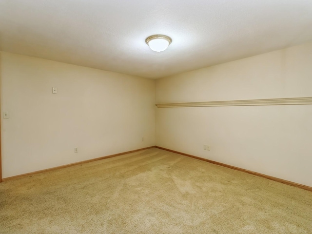 unfurnished room with light carpet and baseboards