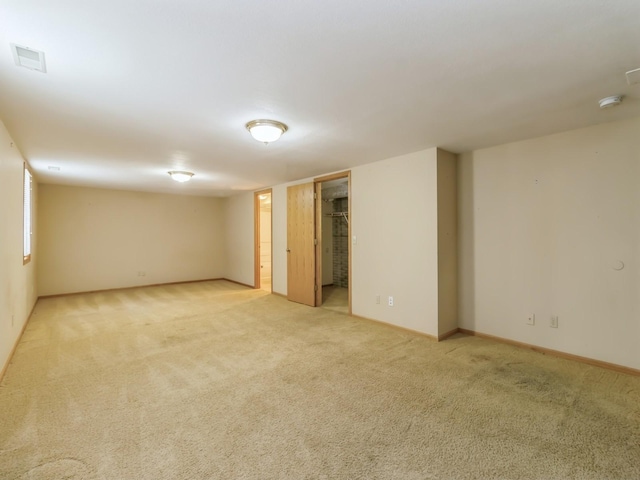 spare room featuring baseboards, visible vents, and light colored carpet