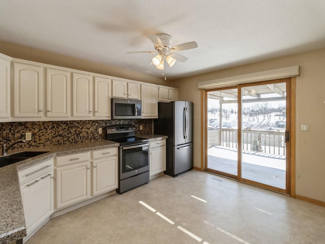 kitchen with dark countertops, backsplash, appliances with stainless steel finishes, a sink, and ceiling fan