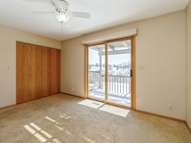 unfurnished bedroom with baseboards, a closet, light colored carpet, and access to exterior