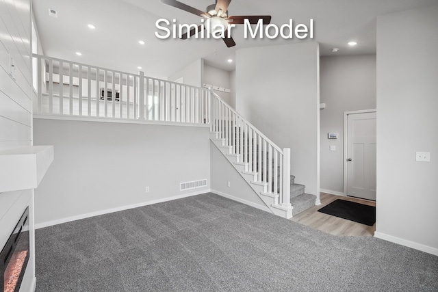 stairs with carpet, recessed lighting, a towering ceiling, and baseboards