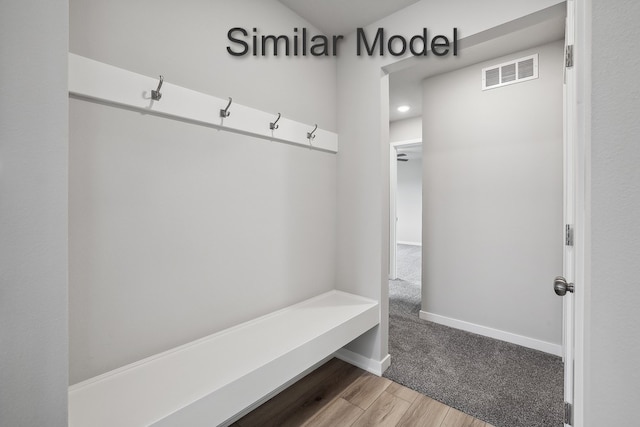 mudroom with wood finished floors, visible vents, and baseboards