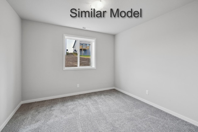 spare room featuring carpet floors, visible vents, and baseboards