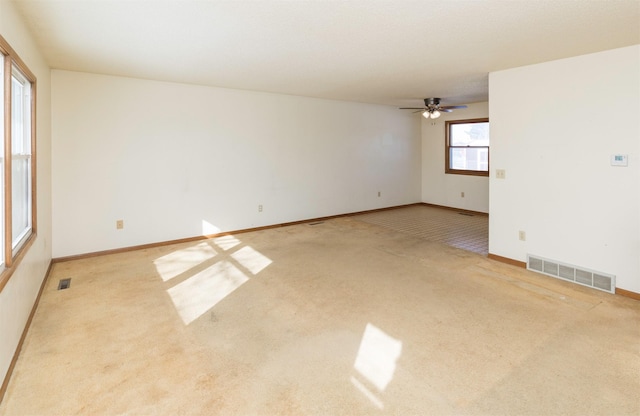 unfurnished room with baseboards, visible vents, and light colored carpet