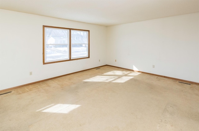 carpeted spare room featuring visible vents and baseboards