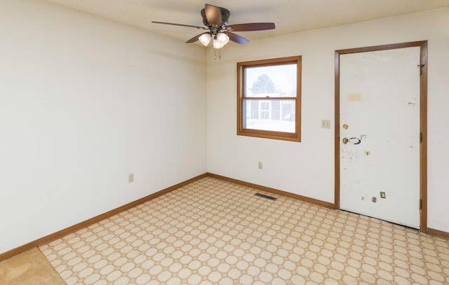 empty room with a ceiling fan, visible vents, and baseboards