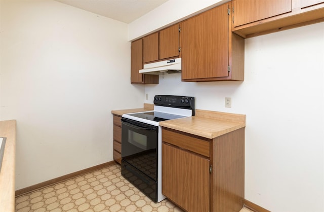 kitchen with light floors, light countertops, black range with electric stovetop, under cabinet range hood, and baseboards