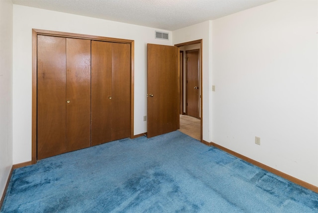 unfurnished bedroom featuring a closet, light colored carpet, visible vents, a textured ceiling, and baseboards