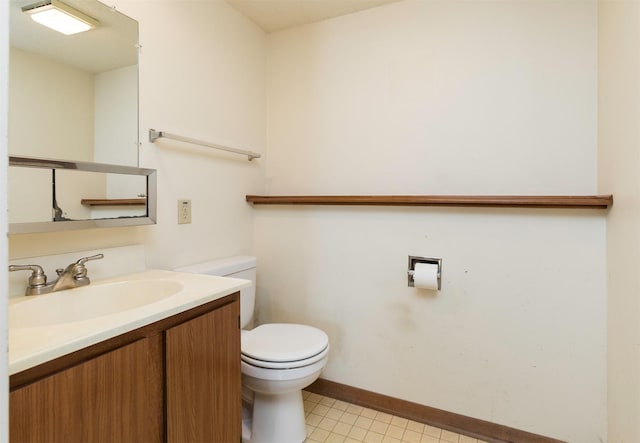 bathroom featuring tile patterned flooring, vanity, toilet, and baseboards