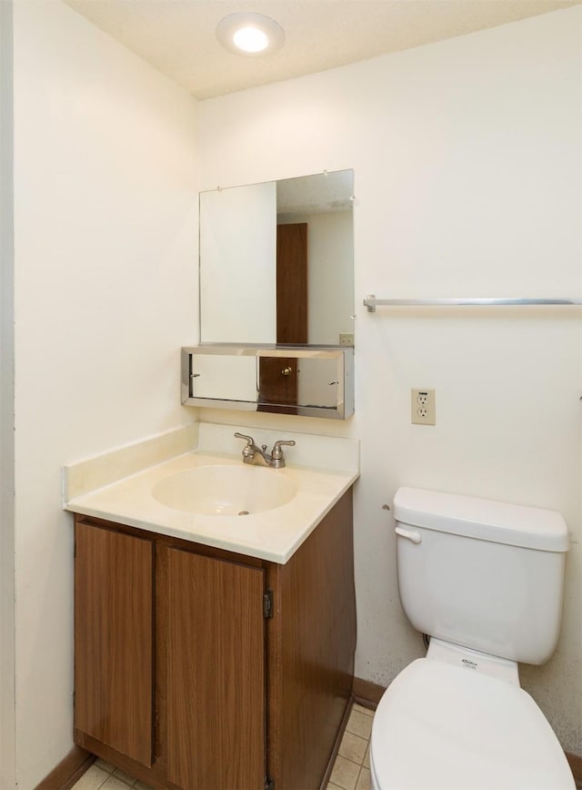 half bath with vanity, toilet, and tile patterned floors