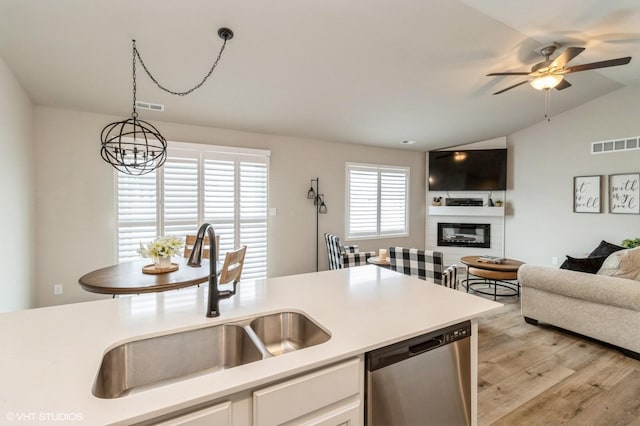 kitchen with light countertops, visible vents, white cabinetry, a sink, and dishwasher