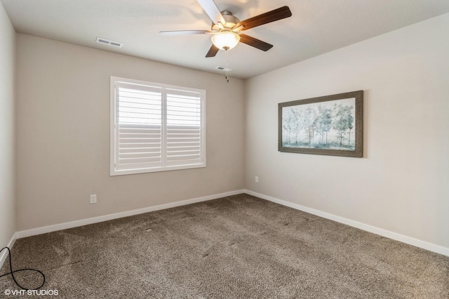 carpeted empty room featuring baseboards, visible vents, and a ceiling fan