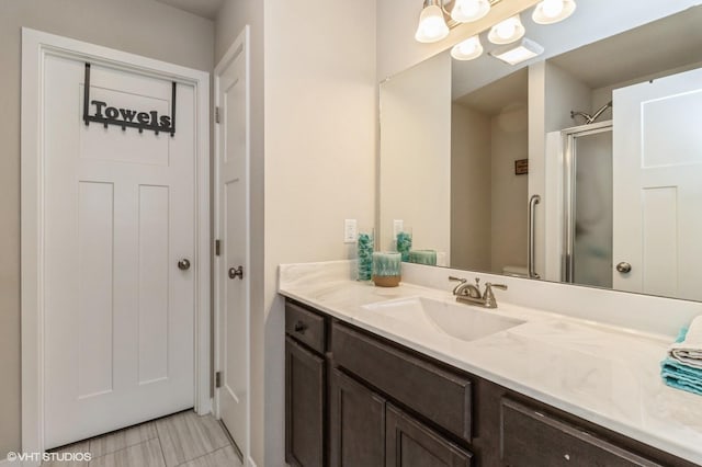 bathroom with vanity and a shower with door