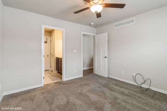 unfurnished bedroom featuring visible vents, light carpet, baseboards, and ensuite bathroom