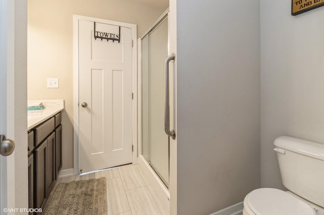 full bathroom featuring toilet, a shower with door, and vanity