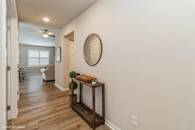 hallway with light wood-style floors, recessed lighting, and baseboards