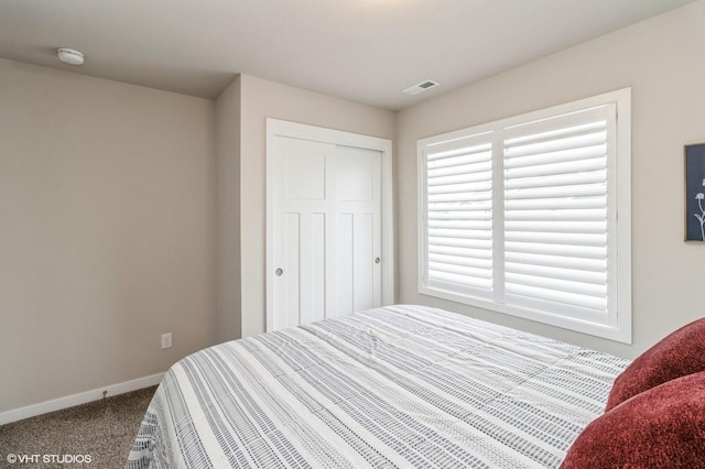 bedroom featuring carpet, a closet, visible vents, and baseboards