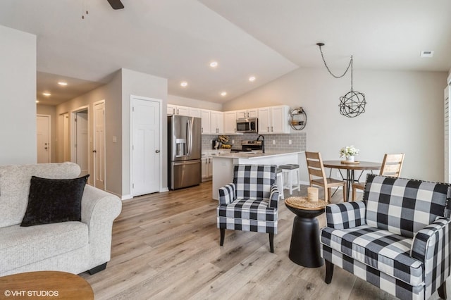 living room featuring light wood-type flooring, recessed lighting, baseboards, and lofted ceiling