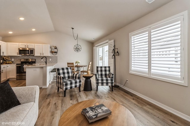 dining space with light wood finished floors, visible vents, baseboards, vaulted ceiling, and recessed lighting