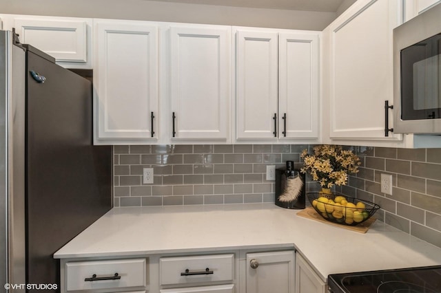 kitchen featuring appliances with stainless steel finishes, light countertops, and white cabinetry