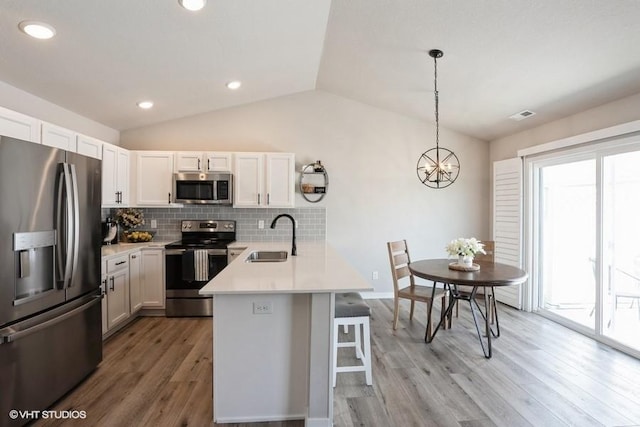 805 Cherry St NW, Bondurant, IA 50035 - kitchen featuring a kitchen bar, stainless steel appliances, backsplash, a sink, and a peninsula