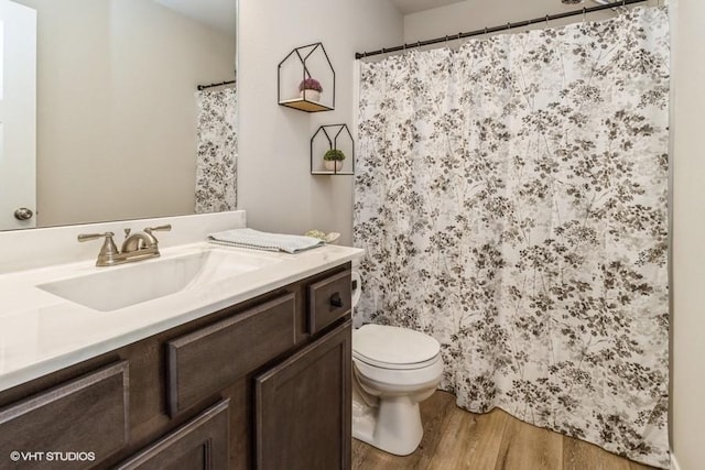 805 Cherry St NW, Bondurant, IA 50035 - bathroom with toilet, vanity, a shower with shower curtain, and wood finished floors