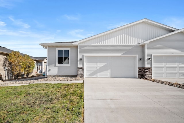 ranch-style home with a garage, concrete driveway, and a front lawn