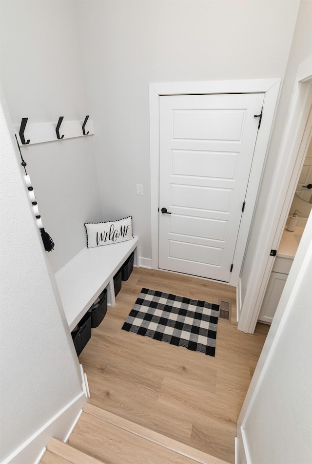 mudroom with light wood-style floors, visible vents, and baseboards