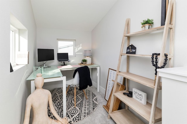 office area featuring vaulted ceiling and light colored carpet