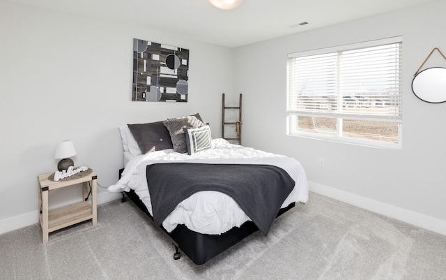 bedroom with light colored carpet, visible vents, and baseboards