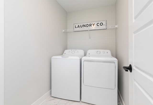 washroom with laundry area, baseboards, marble finish floor, and washing machine and clothes dryer