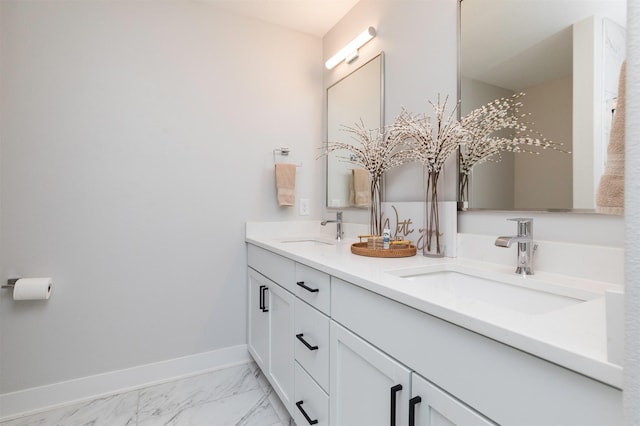 full bath featuring marble finish floor, a sink, baseboards, and double vanity