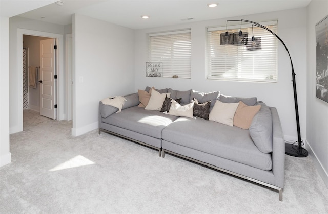 living area featuring baseboards, recessed lighting, visible vents, and light colored carpet