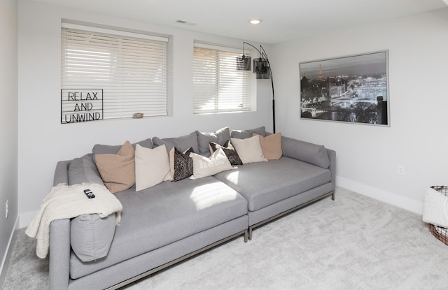 living room with carpet floors, visible vents, and baseboards