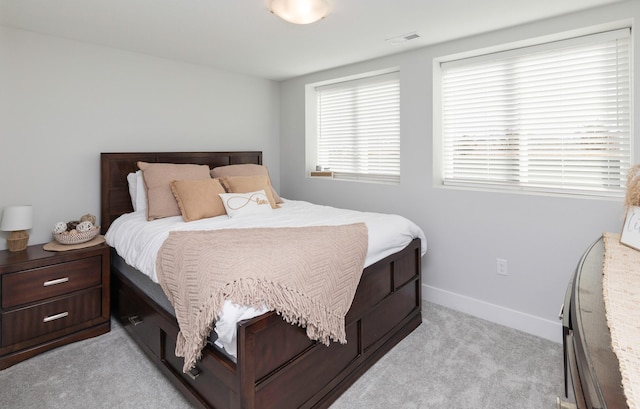 bedroom with light colored carpet, visible vents, and baseboards