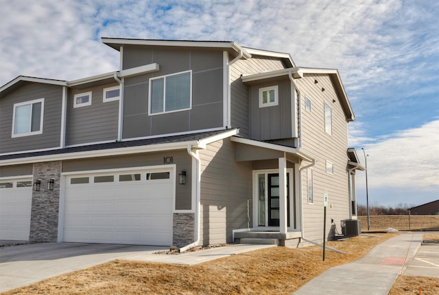 view of front of home featuring concrete driveway, an attached garage, and cooling unit