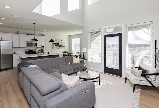 living room featuring light wood-style floors, recessed lighting, and plenty of natural light