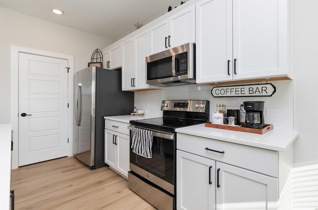 kitchen with stainless steel appliances, white cabinets, light countertops, and light wood finished floors