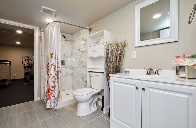 bathroom featuring toilet, a stall shower, vanity, and visible vents