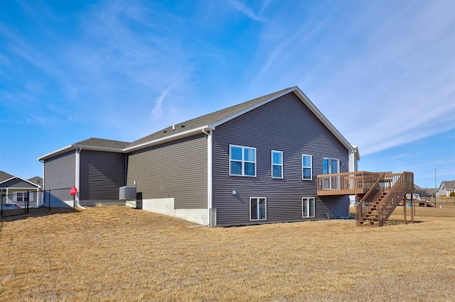 rear view of property with a yard, fence, a deck, cooling unit, and stairs