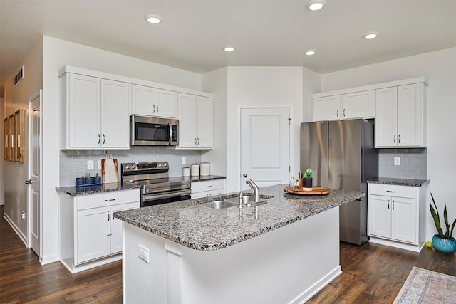 kitchen featuring appliances with stainless steel finishes, a center island with sink, a sink, and visible vents