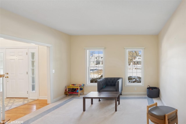 living area featuring light wood-style flooring and baseboards