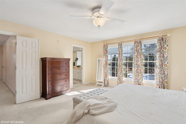 bedroom with a ceiling fan, light carpet, connected bathroom, and a textured ceiling