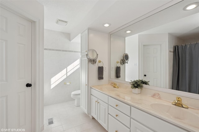 full bath featuring toilet, tile patterned flooring, visible vents, and a sink