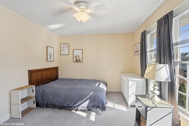 bedroom with light carpet, ceiling fan, and baseboards