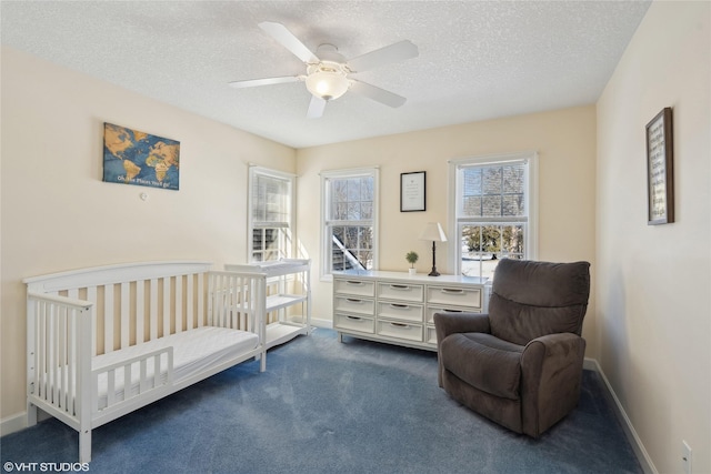 carpeted bedroom featuring a textured ceiling, a ceiling fan, and baseboards