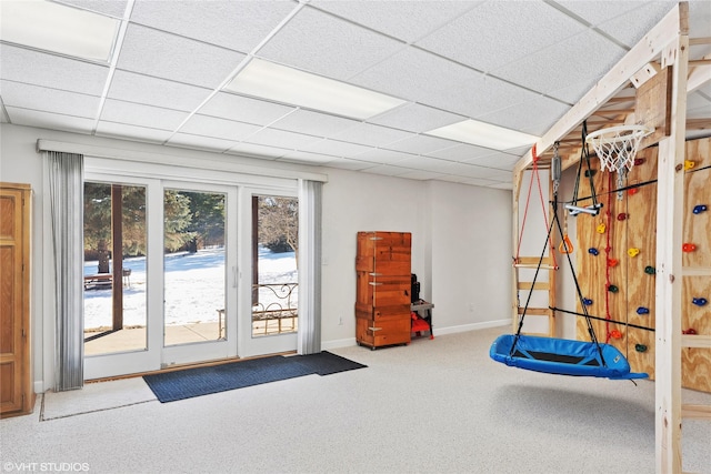 interior space with a paneled ceiling, carpet, and baseboards