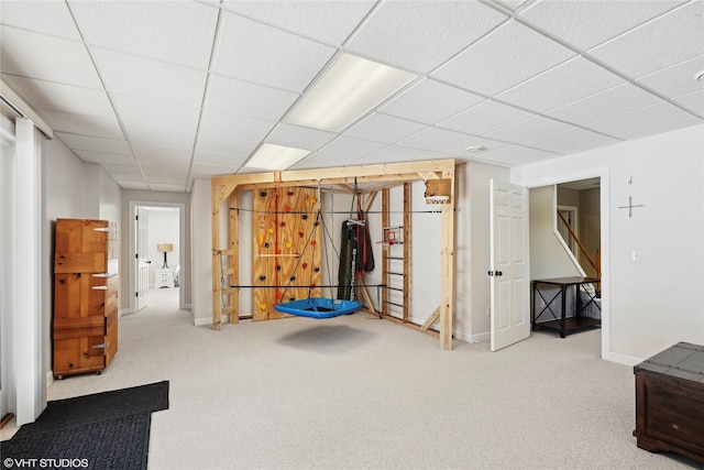 below grade area with carpet floors, a paneled ceiling, and baseboards