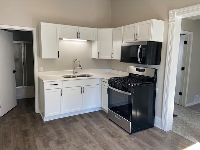 kitchen featuring a sink, white cabinetry, light countertops, and stainless steel range with gas stovetop