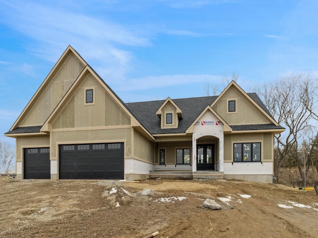 view of front of home featuring a garage, stucco siding, a shingled roof, and french doors